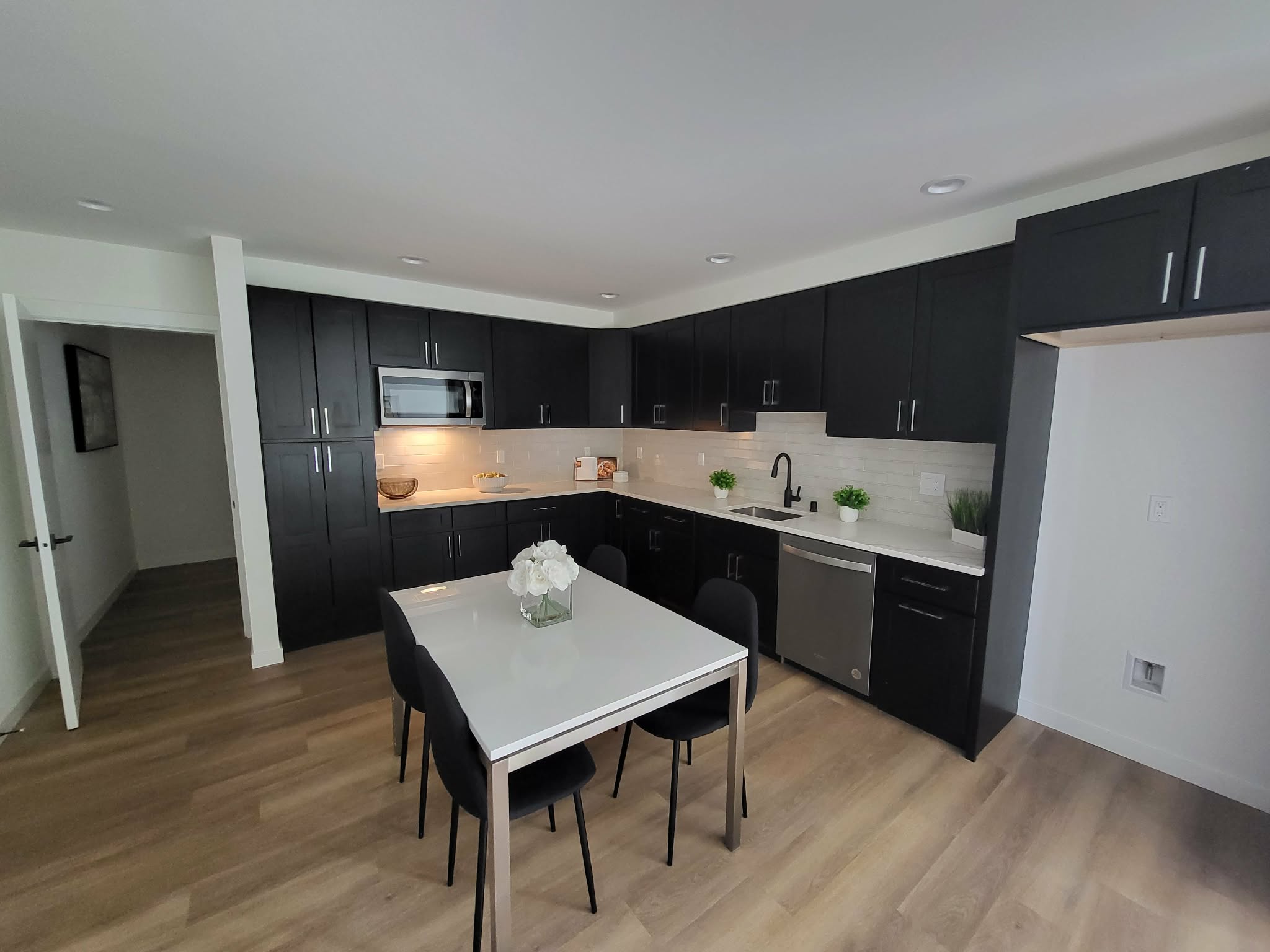 Finished kitchen with dark cabinetry and dining table